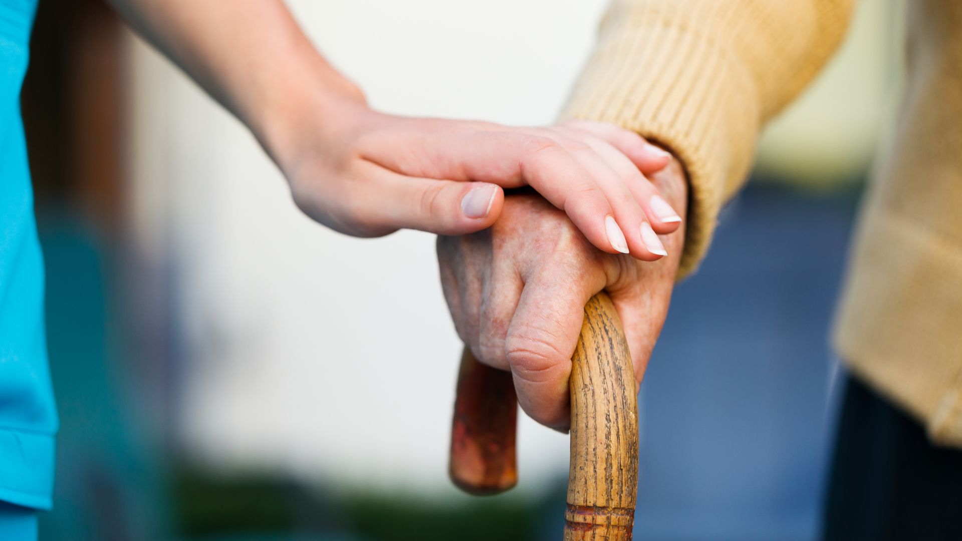 old person leaning on walking stick