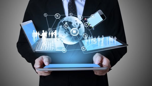 man holding globe in hands between two laptops